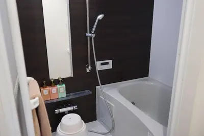 a bathroom with a shower and a tub and a sink at Private Hotel Asakusa in Tokyo