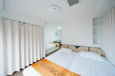 two beds in a room with white curtains at \u6771\u4eac\u30ea\u30ea\u30a2\u30eb\u30db\u30c6\u30eb201 in Tokyo