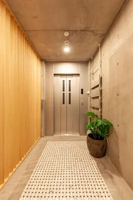 a hallway with a door and a potted plant at Premier suite New Shinjuku Kagurazaka front in Tokyo