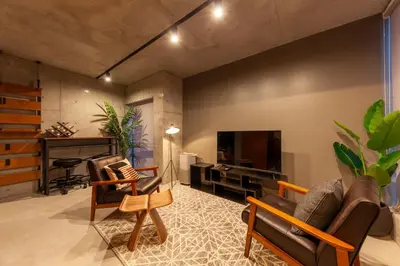 a living room with a tv and a couch and chairs at Premier suite New Shinjuku Kagurazaka front in Tokyo