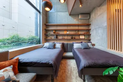 two beds in a room with a couch and a window at Premier suite New Shinjuku Kagurazaka front in Tokyo