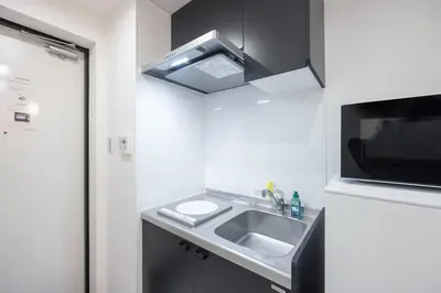 a small kitchen with a sink and a microwave at Arucia\u4e09\u8ed2\u8336\u5c4b in Tokyo