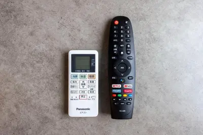 a remote and a cell phone sitting next to each other at Arucia\u4e09\u8ed2\u8336\u5c4b in Tokyo