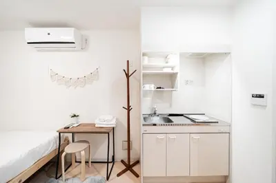 a small white kitchen with a table and a sink at テルヌファビュル亀戸 - Tokyo Urban APT in a Japanese Local Shopping Street, with Direct Access to Shinjuku & Akihabara in Tokyo