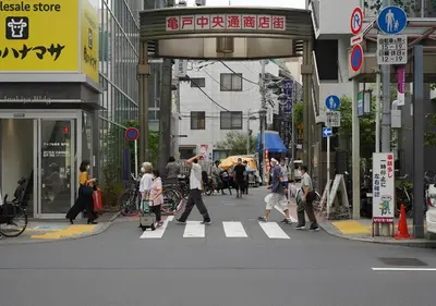 a group of people crossing a street in a city at テルヌファビュル亀戸 - Tokyo Urban APT in a Japanese Local Shopping Street, with Direct Access to Shinjuku & Akihabara in Tokyo