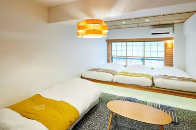 a room with three beds and a table in it at \u6298\u308a\u9db4\u306e\u9593 402 in Tokyo