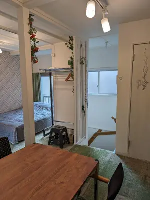 a living room with a table and a bed at UMIBE Apartment in Tokyo