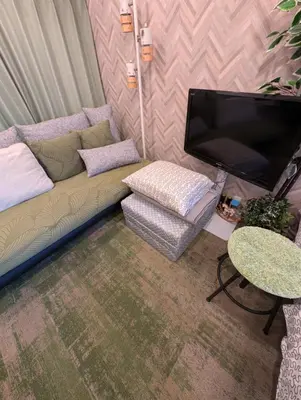a living room with a couch and a flat screen tv at UMIBE Apartment in Tokyo