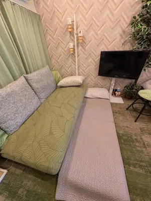 a living room with a couch and a flat screen tv at UMIBE Apartment in Tokyo