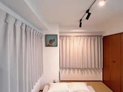 a bedroom with a bed and a window with white curtains at \u4e0a\u91ce\u6771\u4eac\u30bb\u30f3\u30c8\u30e9\u30eb\u30b9\u30c6\u30a4 \u5c71\u624b\u7dda\u99c5\u5f92\u6b693\u5206\u5fa1\u5f92\u753a \u5927\u4eba\u6570 \u30a2\u30e1\u6a2a3\u5206 \u4e0a\u91ce\u99c510\u5206 \u6e6f\u5cf6\u99c52\u5206 in Tokyo