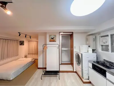 a small kitchen with a bed and a refrigerator at \u4e0a\u91ce\u6771\u4eac\u30bb\u30f3\u30c8\u30e9\u30eb\u30b9\u30c6\u30a4 \u5c71\u624b\u7dda\u99c5\u5f92\u6b693\u5206\u5fa1\u5f92\u753a \u5927\u4eba\u6570 \u30a2\u30e1\u6a2a3\u5206 \u4e0a\u91ce\u99c510\u5206 \u6e6f\u5cf6\u99c52\u5206 in Tokyo