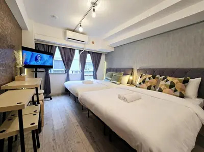 a hotel room with two beds and a flat screen tv at Perfect Hot Location, Shibuya! in Tokyo
