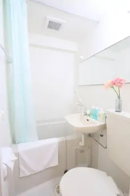 a white bathroom with a toilet and a sink at Perfect Hot Location, Shibuya! in Tokyo