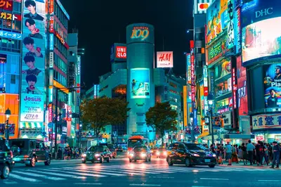 a busy city street at night with lots of traffic at Perfect Hot Location, Shibuya! in Tokyo