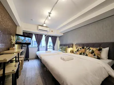 a hotel room with two beds and a desk at Perfect Hot Location, Shibuya! in Tokyo