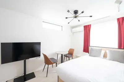 a bedroom with a bed and a flat screen tv at Link COURT\u897f\u65b0\u5bbf in Tokyo