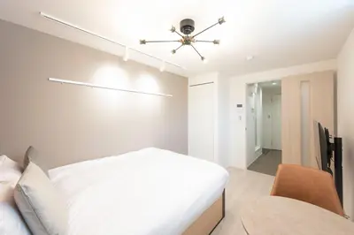 a bedroom with a white bed and a ceiling fan at Link COURT\u897f\u65b0\u5bbf in Tokyo