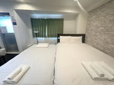 a bedroom with a large bed with two towels on it at \u30a2\u30f3\u30c9\u30b9\u30c6\u30a4\u3059\u3082\u3046\u30db\u30c6\u30eb401 in Tokyo