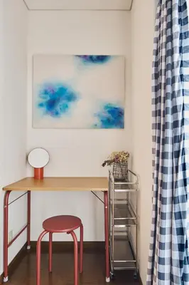 a desk with a red stool and a painting on the wall at Liberty house 7ppl in Tokyo