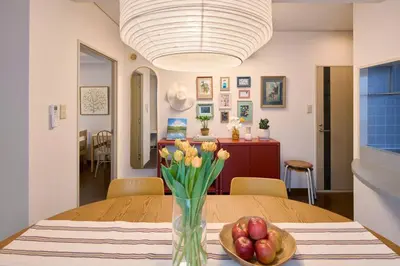 a table with a vase of flowers and a bowl of fruit at Liberty house 7ppl in Tokyo
