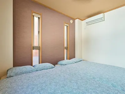a bed in a room with two windows at KandoStay TOKYO\u30c6\u30e9\u30b9 in Tokyo