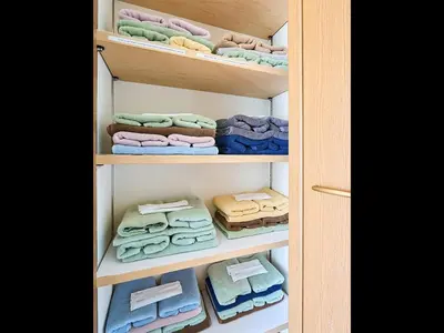 a closet filled with towels and folded clothes at KandoStay TOKYO\u30c6\u30e9\u30b9 in Tokyo