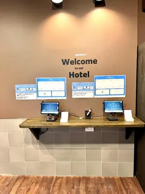 a welcome to our hotel sign on a wall with three computers at \u65b0\u5bbf\u30cb\u30c3\u30ab\u30db\u30c6\u30eb in Tokyo