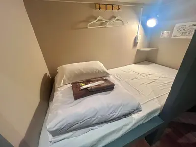 a small bed with a bag on top of it at \u65b0\u5bbf\u30cb\u30c3\u30ab\u30db\u30c6\u30eb in Tokyo