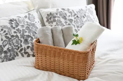 a basket filled with towels on a bed at \u30cf\u30a4\u30af\u30ec\u30b9\u30c8\u4e2d\u91ce201 in Tokyo
