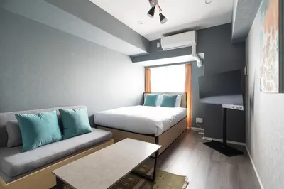 a small room with a couch and a bed at lighthouse otsuka in Tokyo