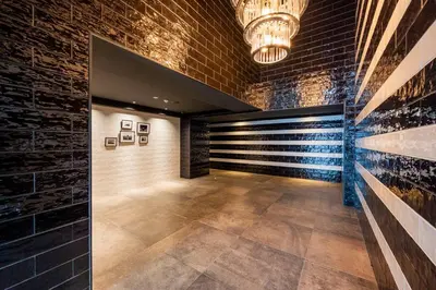 a hallway with a brick wall and a chandelier at lighthouse otsuka in Tokyo