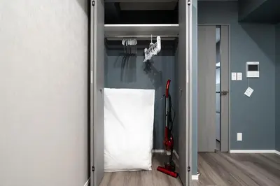 a room with a door with a white bag and a broom at lighthouse otsuka in Tokyo