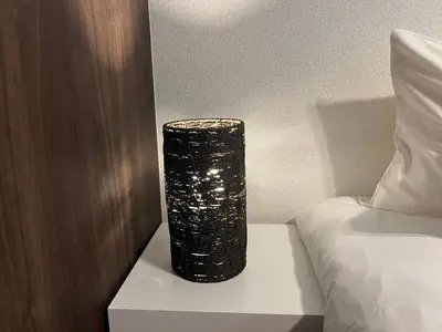 a black vase sitting on a table next to a bed at Ikebukuro Area 41 NishiikeApartment in Tokyo