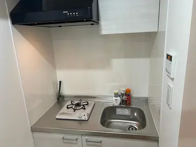 a small kitchen with a sink and a stove at Ikebukuro Area 45 NishiikeApartment in Tokyo