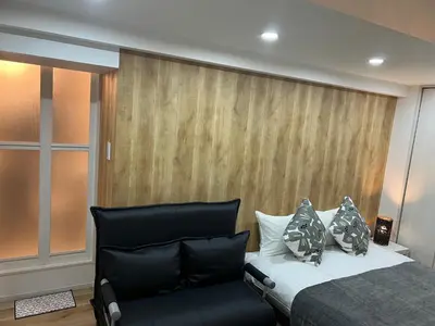 a bedroom with a bed and a chair at Ikebukuro Area 45 NishiikeApartment in Tokyo