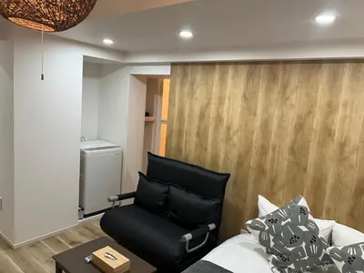 a living room with a black couch and a table at Ikebukuro Area 45 NishiikeApartment in Tokyo