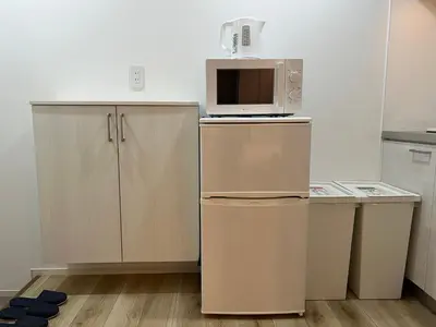 a kitchen with a microwave on top of a refrigerator at Ikebukuro Area 45 NishiikeApartment in Tokyo