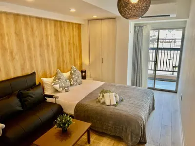 a bedroom with a large bed and a couch at Ikebukuro Area 45 NishiikeApartment in Tokyo