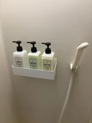 a shelf with four bottles of detergent on a wall at SF Heigths in Tokyo