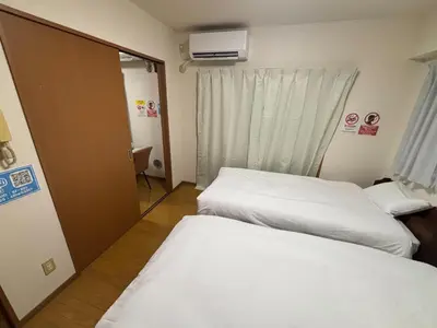 a hotel room with two beds and a mirror at SF Heigths in Tokyo