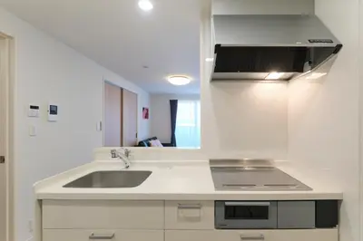 a white kitchen with a sink and a mirror at Victoria \u4e0b\u5317\u6ca2 by Tranova in Tokyo