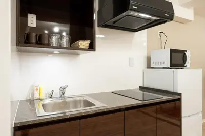 a kitchen with a sink and a microwave at LaVie\u56db\u8c37 in Tokyo