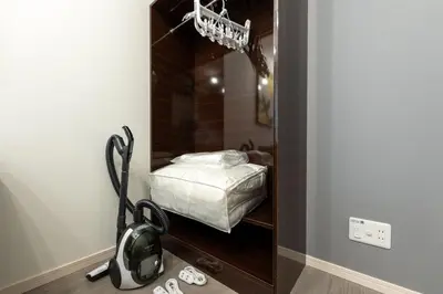 a room with a bedroom with a bed and a vacuum at LaVie\u56db\u8c37 in Tokyo