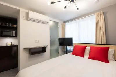 a bedroom with a bed with two red pillows at LaVie\u56db\u8c37 in Tokyo