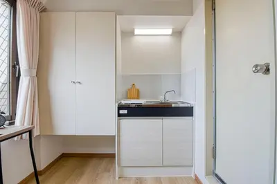a small kitchen with white cabinets and a sink at CraftFlat Komagome 604, compact studio at excellent location in Tokyo