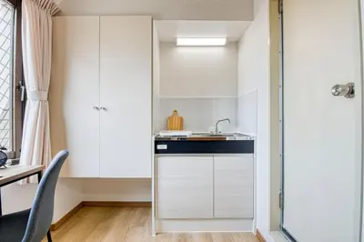 a kitchen with white cabinets and a sink at CraftFlat Komagome 604, compact studio at excellent location in Tokyo