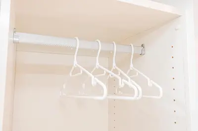 a rack of white kitchen utensils in a closet at 67 Apt Kinshicho in Tokyo