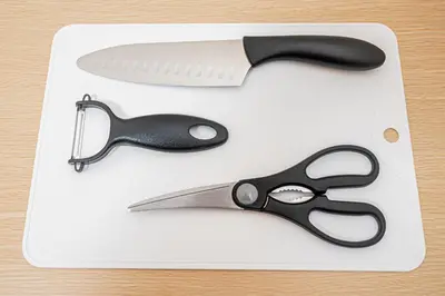 a pair of scissors and a knife on a cutting board at 67 Apt Kinshicho in Tokyo