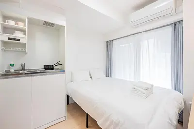a white bedroom with a bed and a window at 67 Apt Kinshicho in Tokyo