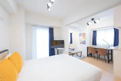 a white bedroom with a white bed and a desk at M S I Kagurazaka in Tokyo